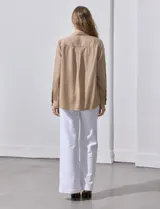 Camisa color verde oliva de lyocell, marca Cyrus. Tiene cuello con solapa, abertura central con botones, mangas 3/4 regulables con presilla y botón, y dos bolsillos delanteros aplicados.