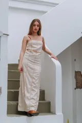 Vestido largo azul con estampado geométrico, tirantes finos y detalles de ribetes oscuros que marcan las costuras.
