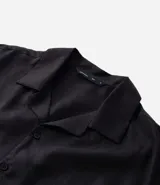 Camisa masculina blanca de lino, modelo boxy, con cuello bowling, manga corta y abotonado delantero.