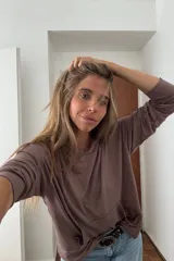 Canguro con capucha de manga larga, color marrón topo, de calce amplio y tejido suave. Presenta bolsillo canguro frontal y puños y ruedo ajustados.