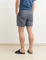 Short de baño azul con estampado geométrico en blanco y negro.