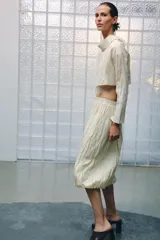 Falda midi de punto con diseño de efecto arrugado y cintura elástica.