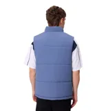 Chaleco acolchado reversible de la marca Rusty, color azul, con cierre frontal completo, cuello alto y bolsillos laterales. Presenta un bolsillo adicional con cierre en el pecho y etiqueta de la marca.