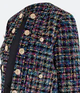 Blazer corto confeccionado en tweed multicolor con forro, escote U, manga larga y botones escudo dorados.