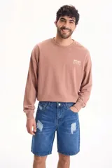 Bermuda de denim azul con roturas y diseño de corte clásico.