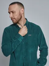 Camisa marrón de pana de manga larga con cuello abotonado y bolsillo en el pecho.