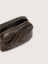 Bolso tipo camera bag de cuero vacuno marrón con acabado envejecido y craquelado, diseño de estrella en relieve en el frente, herrajes dorados y correa de cadena.