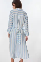 Vestido camisero largo a rayas horizontales verdes y blancas, con cuello clásico, mangas 3/4 y abertura frontal con botones. Confeccionado en lino.