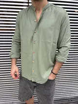 Camisa verde oliva de lino con cuello mao, manga larga y abotonadura frontal.