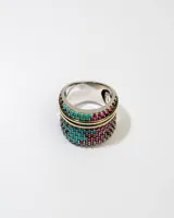 Anillo plateado con doble hilera de piedras turquesas y fucsias.