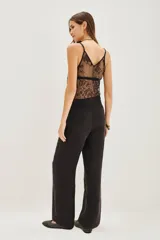 Pantalon palazzo de tiro alto, confeccionado en tejido de cupro con textura sedosa. Presenta una caída fluida, corte recto y bolsillos laterales.