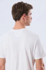 Remera blanca de manga corta y cuello redondo, con estampa frontal inspirada en el mar y atardeceres de verano con la inscripción 'Travel. Beach. Repeat.' y 'Legacy'.