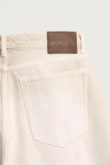 Jeans baggy fit confeccionados en denim de algodón color beige, de corte holgado y amplio en toda la pierna, con tiro medio y diseño de cinco bolsillos.