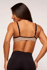 Top deportivo color beige con tirantes finos negros en contraste.