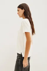 Remera de algodón color blanco con estampa frontal tipográfica en tonos rojo y negro.