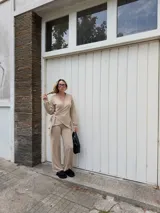 Saco tipo cardigan cruzado de lanilla color beige, con mangas largas y lazo ajustable en la cintura.