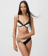 Top de bikini Bossa Nossa con diseño color block en negro y blanco, confeccionado en microfibra con textura plisada. Presenta copa estructurada con aro, breteles finos regulables y un detalle de botón decorativo en el centro.