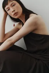 Vestido midi negro confeccionado en punto con efecto arrugado, de escote halter alto con detalle girado y tiras anchas con diseño solapado al frente.