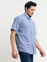 Camisa celeste con microestampado geométrico, de corte clásico, manga corta, cuello abotonado y bolsillo en el pecho.