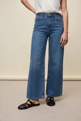 Jean wide leg negro de tiro medio confeccionado en denim con spandex, con bolsillos frontales tipo parche y silueta amplia de corte recto.