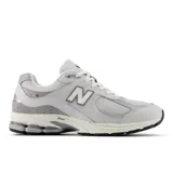 Championes New Balance 2002R, color gris claro, con detalles en gris oscuro y blanco. Confeccionados en malla y cuero sintético, con logo "N" en los laterales y tecnología ABZORB y N-ergy en la entresuela.