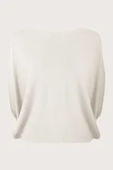 Poncho de punto en color marfil, con diseño de caída relajada, cuello redondo y mangas holgadas.