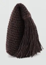 Bolso tipo sobre de fibra natural en color marrón, con diseño tejido y panel frontal de flecos largos.
