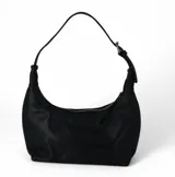Cartera tipo baguette de cuero sintético color negro, con diseño curvo, cierre superior y asa corta regulable con hebilla metálica.