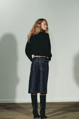 Jersey corto de punto liso, con cuello redondo y manga larga con puños ajustados. Presenta un diseño de corte crop con aberturas laterales en el bajo.