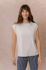 Remera de algodón color crema, con cuello redondo y mangas cortas con dobladillo vuelto. Presenta un corte relajado y estructura en los hombros.