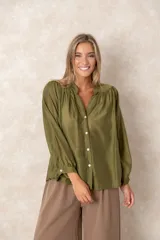 Camisa de organza blanca con cuello mao, diseño de manga larga tipo murciélago y cierre frontal con botones. Presenta un corte holgado y fluido.