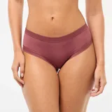 Pack de tres shortys Kiabi confeccionados en microfibra, con detalles de encaje en la cintura y el contorno de las piernas. Incluye un shorty verde con estampado floreado pequeño, uno liso de color rosado y uno en tono crudo con estampado de flores en tonos rojizos y verdes.