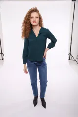 Blusa verde con cuello en V y mangas largas.