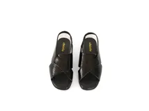 Sandalia de charol negro con tiras cruzadas en el empeine y tira elástica en el talón. Cuenta con plantilla de cuero acolchada y plataforma ligera con un tacón de 3cm.