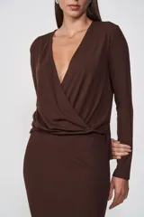 Blusa marrón con escote en V cruzado, mangas largas y nudo lateral.