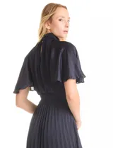 Vestido midi color beige de satén, marca Julia Jordan. Cuello alto con punto smock, mangas amplias de estilo fluido y cintura elastizada también con punto smock. La falda tiene una caída fluida con plisado. Cierre posterior con abertura ojal y botones. Forro interno a tono.