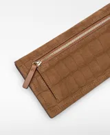 Billetera de cuero con textura de gamuza y grabado efecto cocodrilo, color marrón. Cuenta con cierre de solapa y broche.