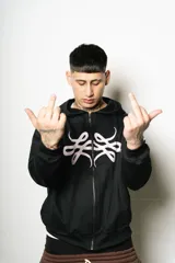 Hoodie con cierre frontal, color negro, de corte regular fit. Presenta un estampado frontal grande en blanco con un diseño abstracto y estilizado, similar a un monograma o símbolo.