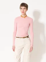 Remera de punto con textura suave, manga larga y escote redondo. Presenta un diseño ajustado al cuerpo con espalda abierta y largo a la primera cadera.