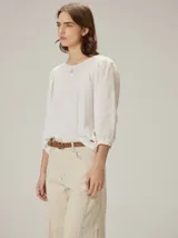 Blusa de diseño combinado con cuerpo delantero y espalda de algodón negro, y mangas abullonadas tres cuartos de lino en color beige con puños elásticos negros.