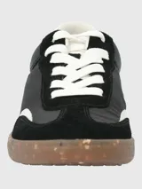 Zapatillas urbanas de diseño deportivo, color negro con detalles en blanco y suela de goma color caramelo con efecto moteado.