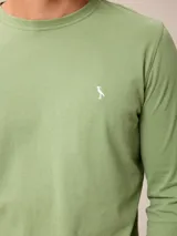 Remera de manga larga color bordó, con cuello redondo y pequeño logo bordado en el pecho.