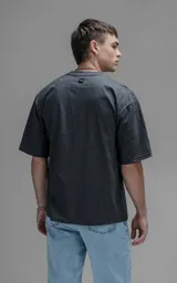 Remera oversized de algodón color gris oscuro melange, de corte relajado, mangas cortas y cuello redondo.