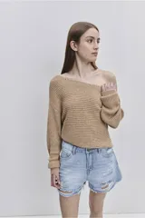 Sweater de punto color tostado, de calce relajado, con escote asimétrico decorado con ojalillos metálicos y mangas largas.