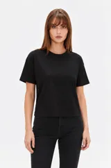 Remera de algodón color negro, con mangas cortas, corte holgado y cuello redondo a la base.
