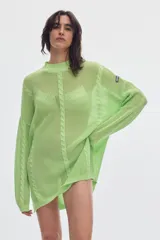 Sweater de punto calado color verde claro, con cuello alto, mangas largas y diseño oversized.