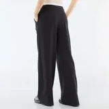 Pantalón de corte ancho y tiro medio, color negro, con detalle de cintura elástica visible estilo bóxer y bolsillos laterales.