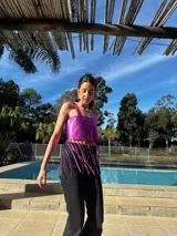 Top corto plateado, estilo bandeau, con tirantes finos y flecos largos en el bajo.
