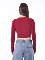 Remera crop top negra de manga larga, con escote en V y detalle de frunce ajustable con lazo en el frente.