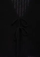 Cardigan de punto crochet color negro, con cuello en pico y cierre frontal mediante lazos. Presenta diseño corto de manga larga y textura calada.